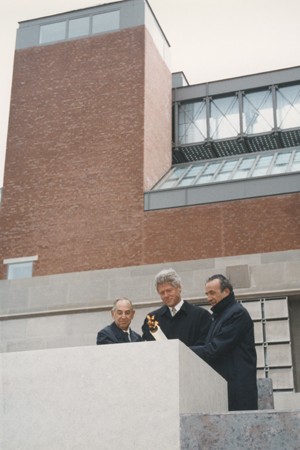 President Bill Clinton (center), Elie Wiesel (right), and Harvey Meyerhoff (left) light the eternal flame outside on the Eisenhower Plaza during the dedication ceremony of the United States Holocaust Memorial Museum.