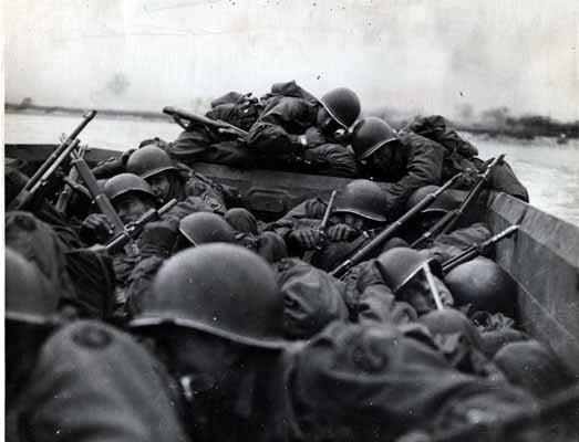 GIs keep low inside a landing craft during an assault across the Rhine at Oberwesel, Germany.