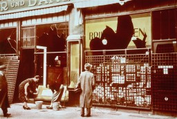 Storefronts of Jewish-owned businesses damaged during the Kristallnacht ("Night of Broken Glass") pogrom. [LCID: 4315]