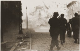 German soldiers direct artillery against a pocket of resistance during the Warsaw ghetto uprising. [LCID: 34083b]