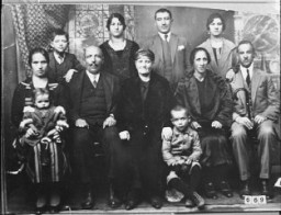 Portrait of an unidentified family of eight adults and three children in Bitola.
This photograph was one of the individual and family portraits of members of the Jewish community of Bitola, Macedonia, used by Bulgarian occupation authorities to register the Jewish population prior to its deportation in March 1943.