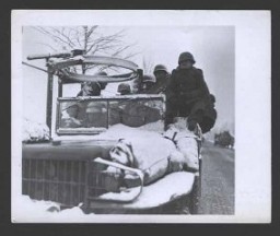 Des GI montent au front dans des camions ouverts, par des températures négatives, en vue d'arrêter l'avancée des Allemands. 22 décembre 1944. Corps de transmission de l'Armée américaine, photo prise par J. Malan Heslop.