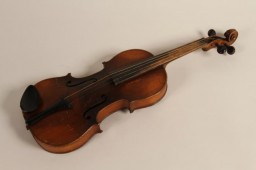 Violin owned by Rita Prigmore and originally used by her father, who played with his four brothers in a band in Germany before World War II. Rita and her family were members of the Sinti group of Roma (Gypsies). She and her twin sister Rolanda were born in 1943. Rolanda died as a result of medical experiments on twins in the clinic where they were born. Rita and her mother survived the war and moved to the United States, before returning to Germany to run a Sinti human rights organization that sought to raise consciousness about the fate of Roma during the Holocaust.
