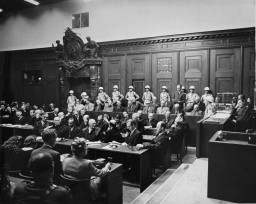 The defendants and their lawyers at the International Military Tribunal trial of war criminals at Nuremberg. Defendant Albert Speer (standing at right) delivers a statement in the dock. Nuremberg, Germany, November 20, 1945-October 1, 1946. 