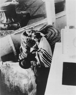 A Jewish passenger prays on board a refugee ship from Germany bound for Argentina in 1938. [LCID: 86618]