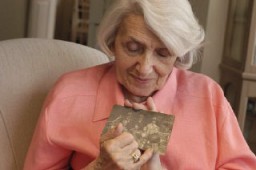 Blanka Rothschild holds one of her prewar family photographs. [LCID: athbr039]