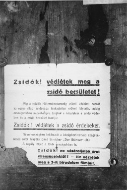 This photo shows a placard urging Hungarian Jews to unite against rising antisemitism in prewar Hungary and Europe. It rallies Jews to protest, using such phrases as: "Protect Jewish honor!”; “Do not buy from our enemies!”; and “Do not watch movies from the Third Reich." Hungary, 1937.