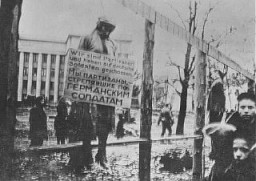 The public hanging of three members of the Communist underground on Karl Marx Street in Minsk. One of the victims wears a large placard around his neck that reads "We are partisans and have shot at German soldiers."This execution was one of four carried out in Minsk on October 26, 1941, by German troops with the 707th Infantry Division. Altogether, 12 members of the Communist underground were publicly hanged in four groups of three near a yeast-making factory. This is believed to be the first public execution after the German invasion of the Soviet Union and it included the hanging of Masha Bruskina, a young Jewish woman. In each of the four cases, the bodies were left to hang for several days to serve as a warning to would-be resisters.