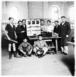 Jewish teenagers study electricity at a vocational ORT (Organization for Rehabilitation through Training) school in the Cremona displaced persons (DP) camp, Italy, 1945–1947. Shie Zoltak is standing on the far left. Standing on the far right is Shie's uncle, Abraham Lisogurski, who is the instructor.