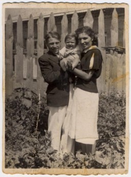 Shlamke and Shanke Minuskin pose with their baby son, Henikel, in the garden of their home. Zhetel, Poland, 1938.
 