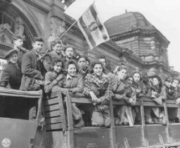 Palesztinába tartó zsidó menekült gyermekek gyülekeznek Németország amerikai megszállás alatt álló zónájában. Egy menekült cionista zászlót lenget. Frankfurt, Németország, 1946. április 10.