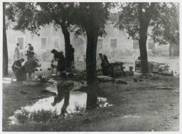 Women prepare food outdoors in the Theresienstadt ghetto. [LCID: 41221]