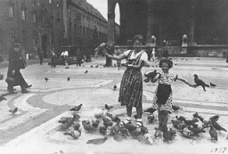 Prewar family photograph of Berta and Inge Engelhard holding pigeons in a public square in Munich. Photograph taken in Munich, Germany, 1937.
Following increased anti-Jewish measures, Berta and brother Theo (not pictured here) left Germany on a Kindertransport in January 1939. Inge followed on a different transport a few months later. While the siblings were eventually housed together in England, they faced many challenges during the war including the pain of separation from their parents.
Parents Moshe and Rachel eventually escaped, and the family was ultimately reunited in England. 