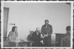 US prosecutor Robert Kempner shows a document to German Field Marshal Erich von Manstein at the International Military Tribunal commission hearings investigating indicted Nazi organizations. Also pictured is the interpreter, a Mrs. Lowenstein. July 1946.