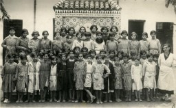 Laurette Cohen (devant à droite) pose avec ses élèves dans l'école d'une Alliance israélite au Maroc. 1935. 
Laurette est née à Oran, en Algérie, en 1911. En 1932, elle épouse Prosper Cohen (né à Meknès en 1909), enseignant comme elle à l'Alliance israélite universelle au Maroc. Leur fille Mathilde naît à Tanger le 31 août 1933. Jusqu'en 1939, la famille vit à Meknès et Fez, puis Laurette et Prosper sont envoyés dans des villes où l'on avait plus besoin d'eux. En 1938, Prosper avait commencé des études de droit. Mathilde était scolarisée dans une école française. Bien que de nouvelles lois raciales aient entraîné l'expulsion de la plupart des élèves juifs, elle est autorisée à poursuivre ses études parce que ses deux parents sont enseignants. 