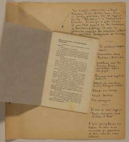 Scrapbook page with handwritten notes in black ink containing one open folded piece of blue paper in the center with printed text in black ink.