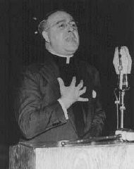 Le père Charles Coughlin, chef du front chrétien antisémite, donne une émission de radio.