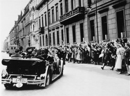 Spectators cheer as Hitler leaves for the Reichstag