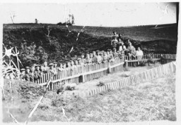 解放后不久，比耶尔斯基（Bielski）游击队成员在乱葬岗遗址前留影。拍摄地点：波兰；拍摄时间：1945 年。