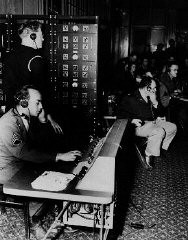 ニュルンベルク裁判では、英語、フランス語、ロシア語、ドイツ語が公用語として使用されました。 裁判の進行を同時通訳している通訳者たち。 通訳者の声は電話交換台を通じて聞き手に送られました。 1945年11月、ドイツ、ニュルンベルク。