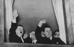Adolf Hitler, Wilhelm Frick, et Hermann Goering font signe lors d'un défilé aux flambeaux en l’honneur de la nomination d’Hitler au poste de chancelier. Rudolf Hess se tient derrière Goering. Berlin, Allemagne, 30 janvier 1933.