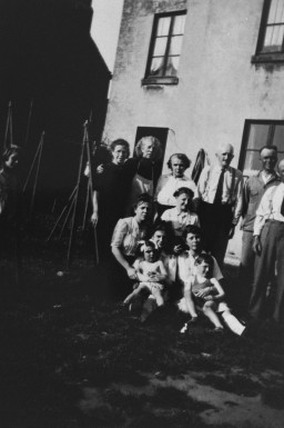 Several family members gather for a photograph that’s been taken at an odd angle. In total, there are ten adults and two children.