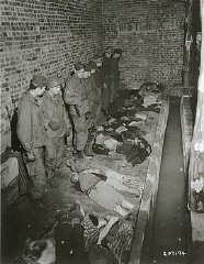 Troops of the American 82nd Airborne Division view bodies of inmates at Wöbbelin, a subcamp of the Neuengamme concentration camp. Germany, May 6, 1945.