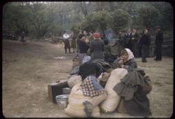 Displaced persons wait next to their suitcases and bundles, place uncertain, ca. 1947.
