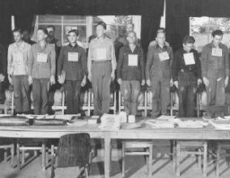 Groupe de 19 hommes accusés d’avoir commis des atrocités au camp de concentration de Dora-Mittelbau, situé à proximité de Nordhausen, au cours de leur procès pour crimes de guerre. Dachau, Allemagne, 19 septembre 1947.