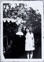 A menina Augusta Feldhorn posa junto a uma freira no local onde estava refugiada.  Ela era judia mas assumiu identidade cristã falsa para permanecer a salvo.  Bélgica.  Foto tirada entre 1942-1945.