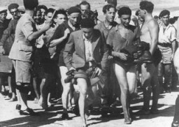 Un policier britannique (à gauche) organisant l’arrestation des passagers du “Patria”, bateau de l’Aliyah Beit (immigration clandestine) après leur débarquement près de Tel-Aviv. Palestine, 22 août 1939.