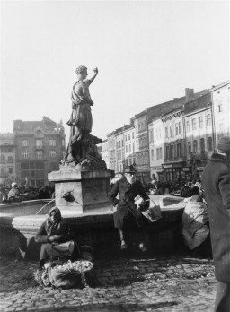An older Jewish man sits on the Adonis fountain on the main square in Lwów, Poland, circa 1938