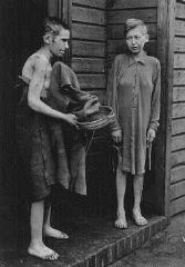 Deux survivants en face des baraques des femmes dans le camp de concentration de Bergen-Belsen.