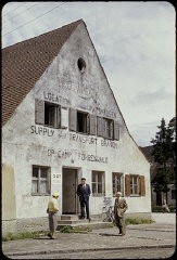 Exterior view of the ORT (Organization for Rehabilitation through Training) supply and transport building in the Foehrenwald displaced persons camp. Foehrenwald, Germany, 1953.
This slide was taken by David Rosenstein during his inspection tour of the camp. After his return from the inspection tour in 1953, he briefed Congress on the plight of the remaining Jewish displaced persons in Europe and their inability to find permanent homes, nine years after the end of the war. 