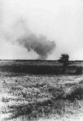 Distant view of smoke from the Treblinka killing center, set on fire by prisoners during a revolt. This scene was photographed by a railway worker. Treblinka, Poland, August 2, 1943.