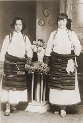 Portrait of two Jewish girls dressed in traditional Macedonian costume in a private home in Bitola. Pictured are Matilda Kamchi (or Camhi, left) and a friend. Both perished in Treblinka. Bitola, 1937.
