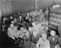 Sopravvissuti del campo di concentramento di Dachau fotografati in una baracca, al momento della liberazione.