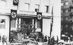 Soldados alemanes invasores izan la bandera nazi frente al ayuntamiento de la ciudad.