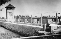 View of the Dachau concentration camp, after liberation on April 29, 1945. It shows the electrified barbed wire fence, the moat, and a watchtower. 