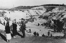 Un membre d’un Einsatzgruppe (unité mobile d'extermination) parle avec deux femmes non identifiées au sommet du ravin de Babi ...