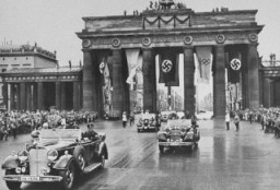 Adolf Hitler az olimpiai játékok megnyitóünnepségére tartva áthalad a Brandenburgi kapu alatt.
