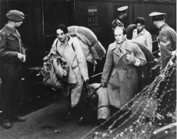 Jewish refugees, forcibly removed by British soldiers from the ship Exodus 1947, arrive at Poppendorf displaced persons camp. Photograph taken by Henry Ries. Germany, September 8, 1947.