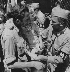<p>American military police admit a father and daughter, both displaced persons, to the refugee shelter at Fort Ontario. Oswego, New York, United States, after August 4, 1944.</p>