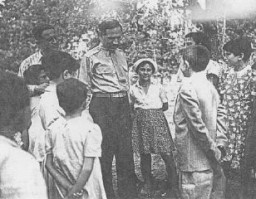 William Bein, director del Comité Judío Estadounidense para la Distribución Conjunta (JDC) en Polonia, con niños en el hogar de Srodborow para niños judíos, cerca de Varsovia. El hogar era financiado por el JDC. Srodborow, Polonia, 1946.