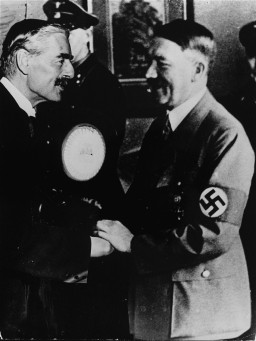 British Prime Minister Neville Chamberlain and German Chancellor Adolf Hitler greet each other at the Munich conference. [LCID: 74614]