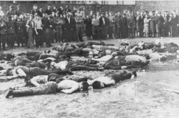 Crowd views the aftermath of a massacre at Lietukis Garage, where pro-German Lithuanian nationalists killed more than 50 Jewish men. The victims were beaten, hosed, and then murdered with iron bars. Kovno, Lithuania, June 27, 1941.