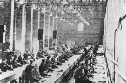 Para tahanan tengah melakukan kerja paksa di pabrik Siemens. Kamp Auschwitz, Polandia, 1940-1944.