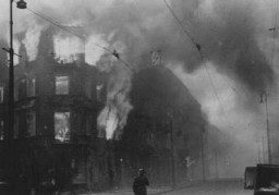 Jewish homes in flames after the Nazis set residential buildings on fire in an effort to force Jews out of hiding during the Warsaw ghetto uprising. Poland, April 19–May 16, 1943.