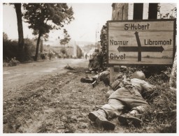 American soldiers of the 8th Infantry Regiment seek cover behind hedges and signs to return fire to German forces holding the town ... [LCID: 80482]