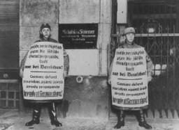 Membres des SA (Sturmabteilung, sections d’assaut) faisant le piquet devant un commerce appartenant à un Juif lors du boycott.